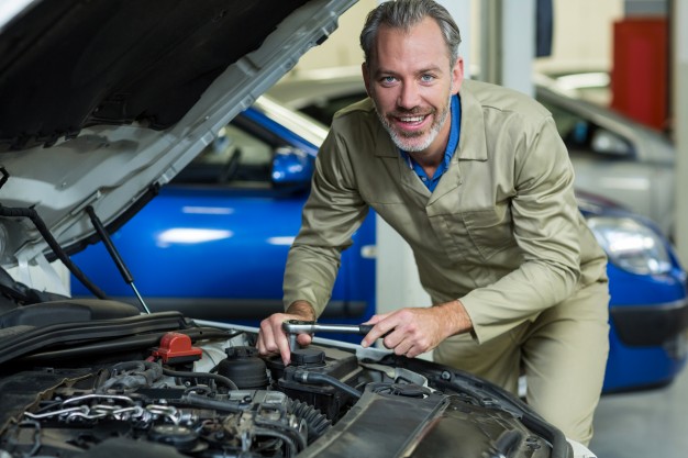 Happy Auto Mechanic working on a customer's car at Capital Performance